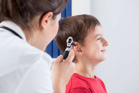 Otolaryngologist using otoscope to examine childの写真素材