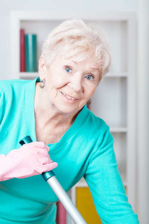 Portrait of smiling elderly woman washing floorの写真素材