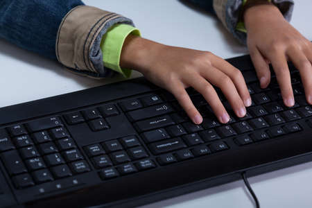 Close-up of child's hands typing on keyboardの写真素材