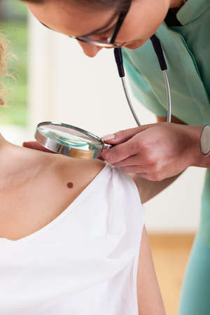 Dermatologist checking up his patient for melanoma