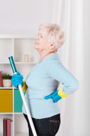 Senior woman having back pain during washing floorの写真素材