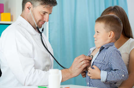 Pediatrist examinate young patient's lungs with stethoscope