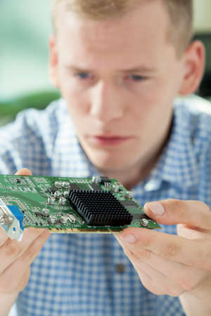 Portrait of young hardware expert holding processor