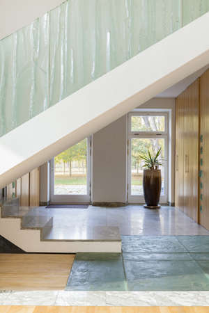 Photo of modern stylish hallway with big stairs