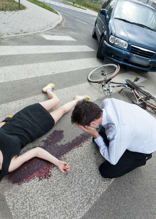 A dead woman lying on the road and a driver cryingの写真素材