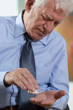 Close-up of elderly dignified man taking the medicineの写真素材