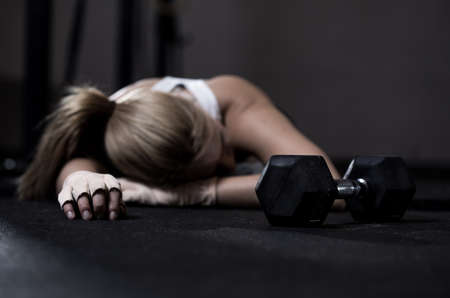 Young exhausted girl lying on a floor after trainingの写真素材