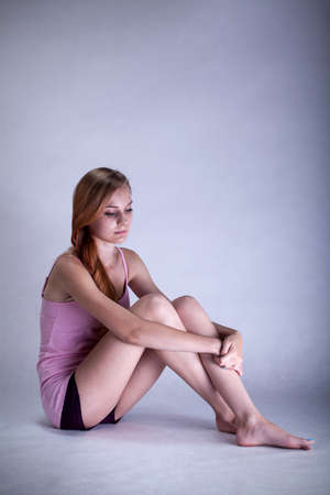 Portrait of depressed woman sitting on the floorの写真素材