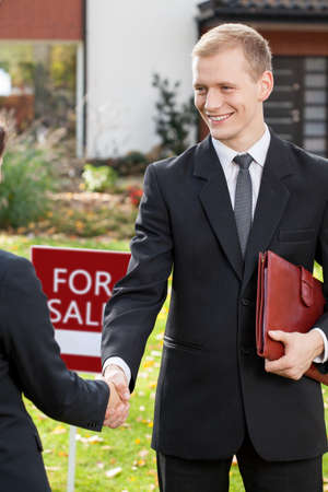Smiling estate agent shaking hand of clientの写真素材