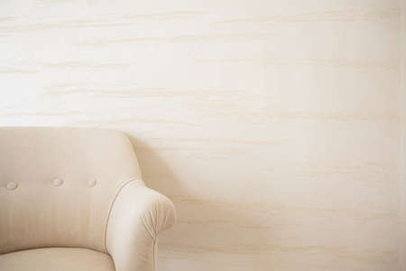 Beige armchair on a background of bright wallの写真素材