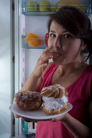 Sweet snacks at midnight in greedy girl's hands