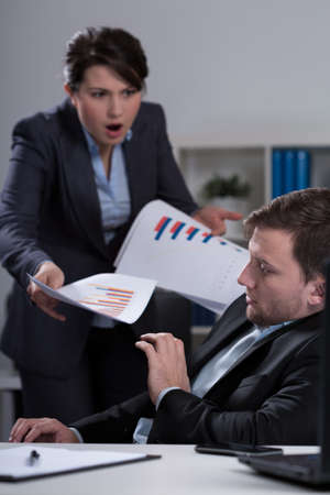 Young furious female boss and her scared young employeeの写真素材