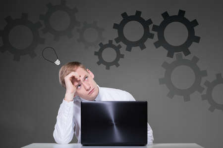 Businessman sitting at the desk and searching solutionの写真素材