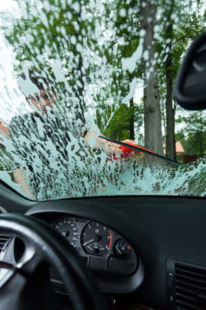 White soap suds of cleanser on the car windowの写真素材