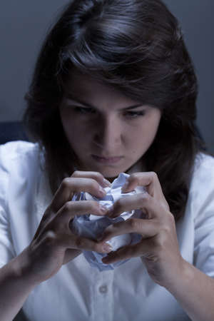 Close-up of frustrated woman holding crumpled documents