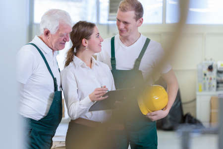 Female engineer talking with plant workers in factory