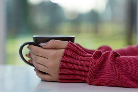 Horizontal view of woman drinking hot tea