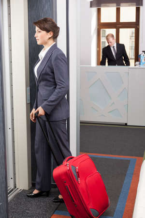 Young pretty woman with case going to her hotel roomの写真素材