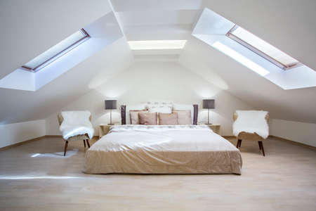 Bright attic bedroom in the fashionable apartmentの写真素材