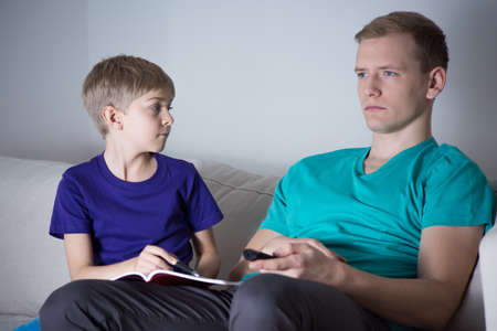 Child asking dad for help with homeworkの写真素材