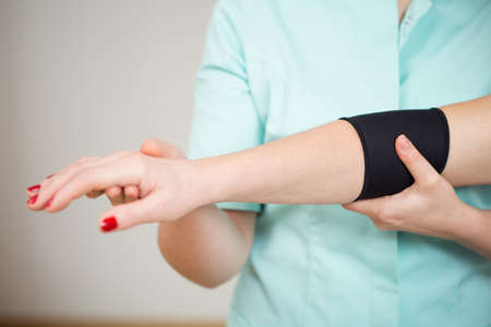 Close-up of woman's sick arm with protective bandの写真素材
