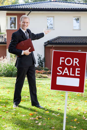 Young handsome real estate agent showing the house for saleの写真素材