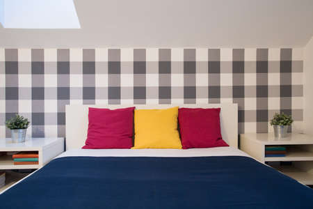 Double bed with color cushions in cozy bathroomの写真素材