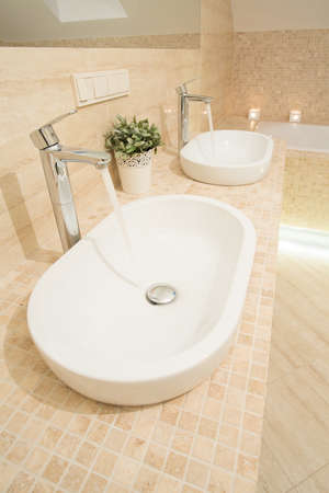 Close-up of two washbowls with running waterの写真素材