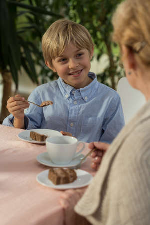 Smiling little boy and his granny during five o'clock teaの写真素材