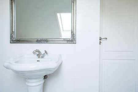 Washbasin and mirror in clean white toiletの写真素材