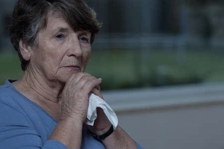 Close-up of elderly crushed lady with tissueの写真素材