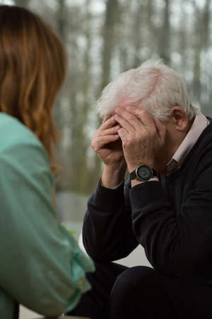 Elder man crying during visit in psychiatristの写真素材