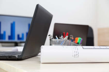 Close-up of laptop and blueprint on the tableの写真素材