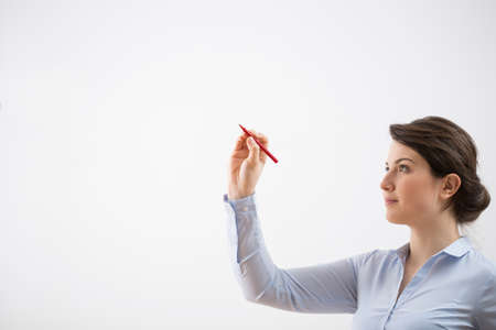 Young elegant woman creating on glass boardの写真素材