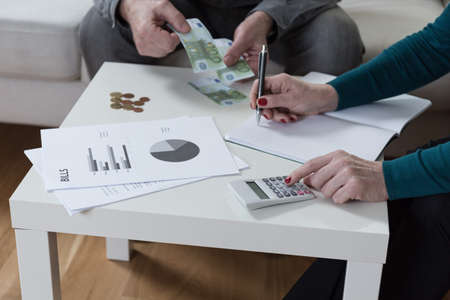 Close-up of marriage writing down their expensesの写真素材