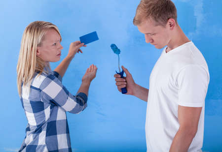 Man painting wall for bad colour and unsatisfied girlの写真素材