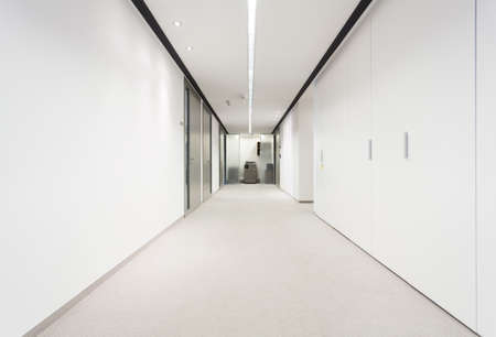 Illuminated long corridor in modern office building