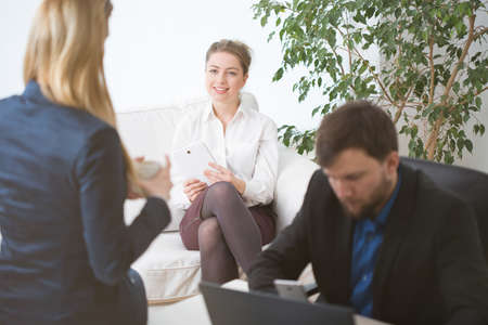 Three young businesspeople and their coffee time at workの写真素材