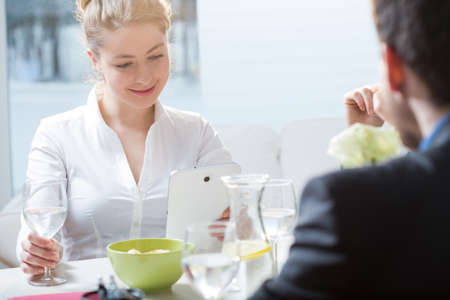 Young pretty businesswoman using her tablet during lunchの写真素材