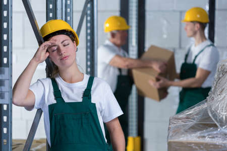 Young tired woman working in warehouse