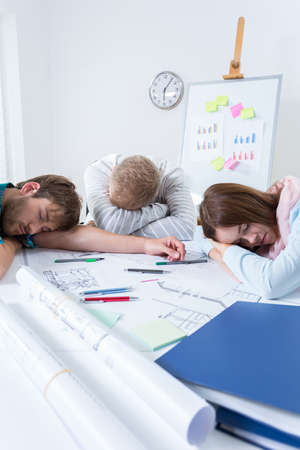 Architectural team sleeping after long night in the officeの写真素材