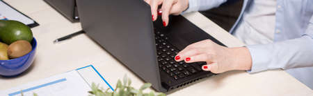 Close-up of elegant older businesswoman working on laptop