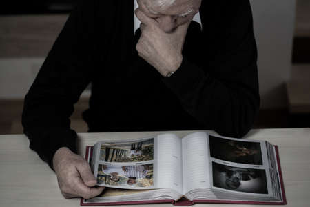 Lonely elderly man recollect happy memories from his lifeの写真素材
