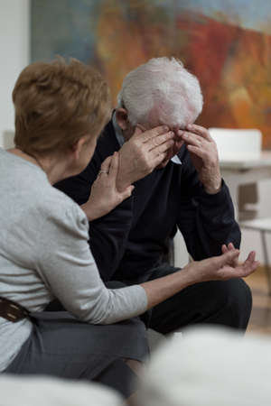Elder woman supporting her sad senior husbandの写真素材