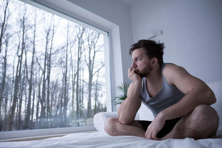 Man suffering from sleeplessness biting his nails