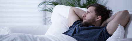 Male lying in bed with open eyes