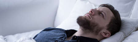 Man suffering from sleeplessness lying with open eyes