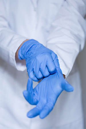 Doctor hands in gloves at work in hospitalの写真素材
