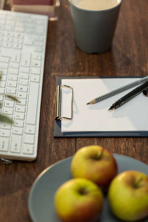 Juicy apples and coffee cup on workplaceの写真素材