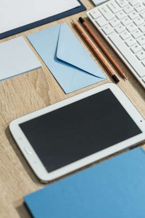 Smartphone and office supplies on wooden deskの写真素材